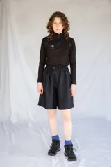 Bermuda holgada negra con cintura elastizada y hebillas de ajuste.