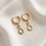 Caravanas de acero dorado con diseño de símbolo de infinito colgante.