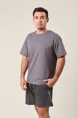 Bermuda deportiva gris oscuro de nylon, de corte suelto, con cintura elástica y cordón de ajuste. Cuenta con detalles de líneas en los costados y bolsillos con cierre.