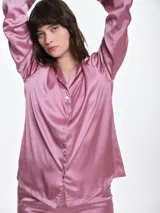 Camisa de dormir de satén con cuello solapa, cierre frontal con botones y mangas largas. Presenta un corte holgado y fluido.