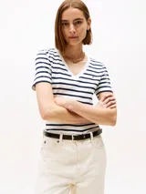 Remera de manga corta ajustada al cuerpo, con cuello en V y estampado de rayas horizontales blancas y azul marino. Presenta un pequeño logo bordado en el pecho.