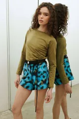 Short de tafeta negro de tiro alto, con botón de nácar y cinturón verde incorporado con tiras largas para atar.