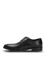 Zapato de vestir formal Hush Puppies modelo Blues, confeccionado en cuero negro con cierre de cordones. Presenta una silueta clásica con puntera redondeada y suela de goma resistente.