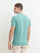 Remera polo azul marino de manga corta, con cuello y tapeta de dos botones. Presenta aberturas laterales en el dobladillo.