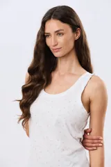 Musculosa de algodón color beige con delicado estampado floreado, escote redondo y pequeños volados en las sisas.