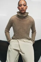 Jersey de punto calado color beige, con cuello alto vuelto y manga larga, confeccionado en lino.