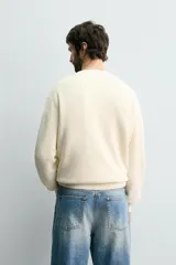 Sweater de punto perlado en color gris, con diseño relaxed fit, cuello redondo y manga larga. Cuenta con acabados en rib en cuello, puños y dobladillo.