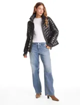 Campera puffer con acabado satinado de alto brillo, diseño capitoneado con líneas horizontales y en V. Cuenta con cierre frontal metálico, capucha fija, bolsillos laterales con cierre invisible y puños internos elastizados con abertura para el pulgar.
