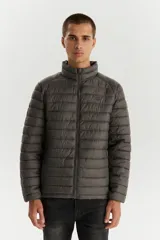Campera puffer de diseño acolchado, color gris oscuro, con cuello alto, cierre frontal completo y bolsillos laterales con cierre.