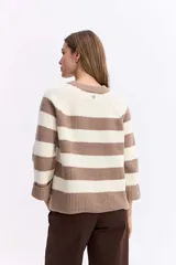 Buzo de punto con diseño de rayas horizontales anchas en color negro y celeste. Presenta cuello redondo, mangas largas y un corte holgado con terminaciones acanaladas.