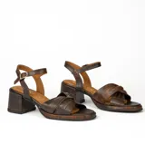 Sandalias de cuero color dorado, con plataforma y taco cuadrado. Presentan tiras cruzadas en el empeine y pulsera al tobillo con hebilla.