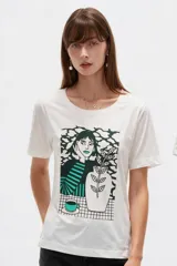 Remera de algodón de manga corta, color blanco, con cuello redondo y estampa frontal de diseño ilustrativo en tonos marrones y fucsia.