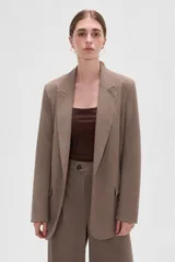 Blazer de corte holgado con diseño de rayas verticales, cuello solapa y cierre frontal con un botón. Presenta bolsillos laterales con solapa y mangas largas.