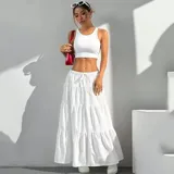 Pollera larga blanca de tiro alto con diseño acampanado y volados en capas. Cuenta con cintura elástica fruncida y lazo ajustable del mismo tejido.