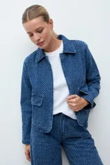 Chaqueta de jean azul con textura de efecto desgastado, cuello clásico y cierre frontal.