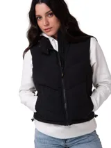 Chaleco puffer negro de diseño cropped, sin mangas, con cuello alto, cierre frontal de cremallera y bolsillos laterales.