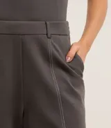 Pantalón recto gris oscuro de cintura alta con trabillas, confeccionado en tejido ponto roma con viscosa sostenible. Presenta costuras dobles aparentes en la parte delantera y en el ruedo.