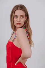 Vestido corto blanco con tirantes decorados con cuentas coloridas de piedra.