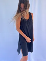 Vestido playero de corte holgado y diseño minimalista, confeccionado en algodón. Presenta cuello redondo, sisas amplias y aberturas laterales en el ruedo con pespuntes en contraste.