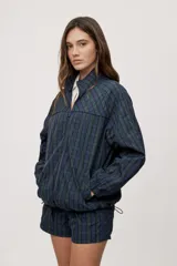Campera liviana de calce relajado con estampado a cuadros en tonos de azul y verde. Cuenta con cuello alto, cierre frontal y mangas largas.