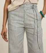 Pantalón wide leg de sarga con rayas verticales en blanco y negro, cintura alta con cinturón fino y trabillas.