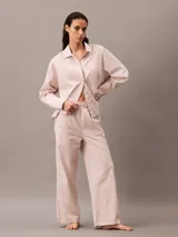 Pantalón de pijama de corte relajado y pernera ancha, confeccionado en popelina de algodón. Presenta cintura elástica con etiqueta de marca y bolsillos laterales.