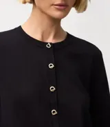 Cardigan negro de punto con escote redondo, mangas largas y cierre delantero con botones dorados.