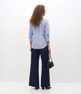 Camisa de tricolina de algodón con estampa de rayas celestes y blancas, cuello solapa, abotonado frontal y mangas largas. Marca Cortelle.