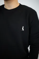 Buzo negro de algodón de punto, corte clásico y cuello redondo.