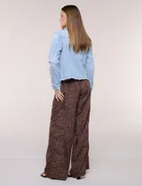 Campera de jean Baccini de color celeste claro, con cuello solapa, cierre frontal con botones metálicos, bolsillos en el pecho y ruedo con terminación desflecada.