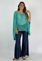 Top tejido de crochet color celeste, con mangas largas acampanadas y cuello redondo.