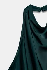 Top de cuello halter color verde oscuro, con escote drapeado, manga sisa y bajo asimétrico. Cierre en la espalda.