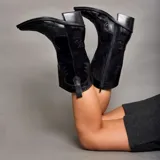 Bota texana de caña alta color marrón claro, confeccionada en cuero vacuno con detalles de bordado y apliques en relieve. Tiene cierre lateral, taco de madera con folia de cuero y suela de goma. La horma es de punta fina, ancha y cómoda.