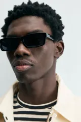 Cazadora de hombre color beige claro, corte relajado, con cuello solapa, manga larga y puños con botones a presión. Presenta bolsillos de plastrón con solapa en la cadera y cierre frontal de cremallera oculta por solapa de botones a presión.