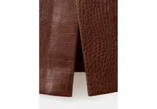 Falda midi tubo de color marrón con textura efecto piel de cocodrilo, tiro alto y diseño recto.
