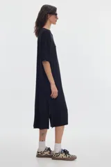 Vestido midi de rib color negro, con cuello redondo y manga corta, diseño holgado y aberturas laterales en el bajo.