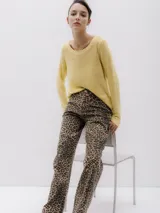 Sweater de punto color amarillo, con cuello redondo y mangas largas. Corte regular y textura suave.