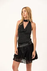 Pollera mini de encaje negro con diseño de volados irregulares y corte acampanado.