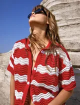 Conjunto de dos piezas de tejido de punto con diseño de ondas horizontales en color rojo y blanco. Incluye una camisa de manga corta con cierre frontal de botones y un short de tiro medio con cintura elástica.