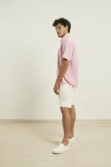 Camisa sport de manga corta, confeccionada en una mezcla de lino y algodón. Presenta cuello clásico, cierre frontal con botones de coco y un bolsillo aplicado en el pecho.