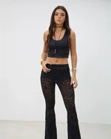 Pantalón de encaje negro con corte oxford, de tiro medio y ajuste ceñido en la parte superior con terminación acampanada.