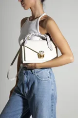 Mini bolso de mano Schutz modelo Brera, color blanco con textura granulada, solapa frontal con cierre metálico dorado y plateado, asa superior decorada con pañuelo estampado y correa ajustable para llevar al hombro o cruzado.