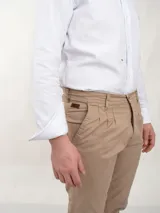 Pantalón de vestir azul marino, de corte recto, con bolsillos laterales y traseros. Se ajusta a la cintura con cinturón de cuero marrón.