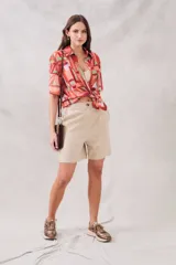 Bermuda color beige de lino y viscosa, tiro medio, corte recto y largo a la rodilla.