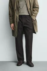 Pantalón de corte regular fit confeccionado en tejido mezcla de algodón. Presenta cintura con detalle de pliegues en el delantero, bolsillos frontales y bolsillos traseros de vivo con botón. Cierre frontal con cremallera y botón.