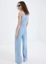 Mono largo de denim suave celeste, sin mangas, con cuello redondo, tirantes finos y pantalón de corte recto y holgado.