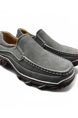Mocasín de hombre estilo casual, color gris, confeccionado en material sintético con costuras blancas visibles y suela robusta de goma.