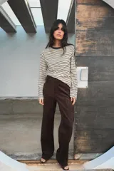 Pantalón de tiro alto confeccionado en tejido con efecto ante, de corte recto y diseño minimalista con trabillas en la cintura y cierre frontal con cremallera y gancho metálico.