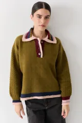 Buzo de lana tipo polo con cuello y cartera de botones en colores contrastantes. Presenta mangas con textura de ochos y puños y ruedo con terminaciones en franjas de colores.
