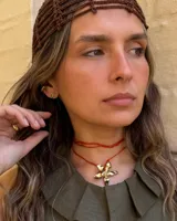 Collar tipo gargantilla con dije de flor metálica de acabado brillante, suspendido de un cordón doble de seda natural teñido a mano en color rojo.